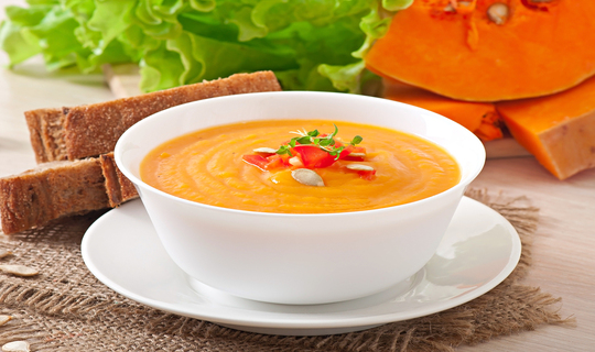 A white ceamic bowl of healthy pumpkin soup for better living.