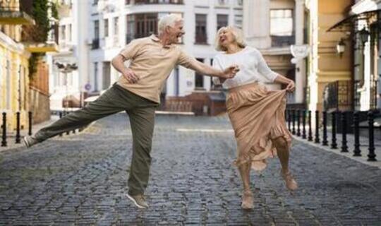 Eldely man and woman having fun dancing in the city growing old with grace and dignity.